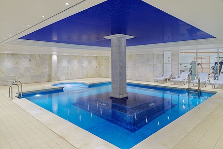 Una piscina al aire libre, sillones reclinables de piscina