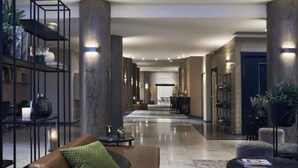 A spacious lobby with high ceilings, a central seating area, and a reception desk.