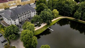 An aerial view of a building with a parking lot and a lake.