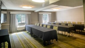 A conference room with a long table, chairs, and windows with curtains. - Holiday Inn Salem - I-93 at Exit 2 by IHG (Salem)