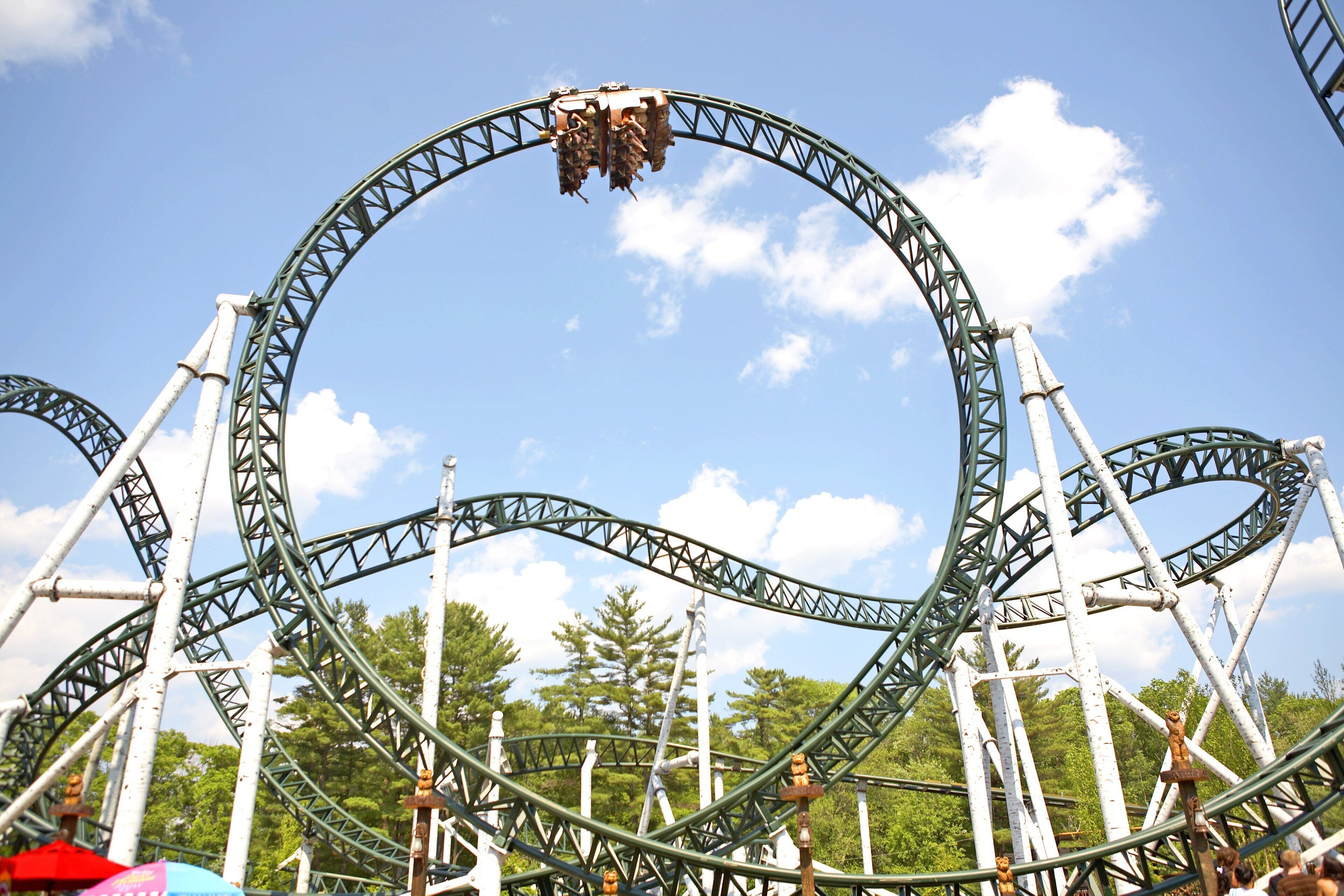 A roller coaster with a circular track and a clear sky in the background.