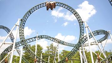 A roller coaster with a circular track and a clear sky in the background.