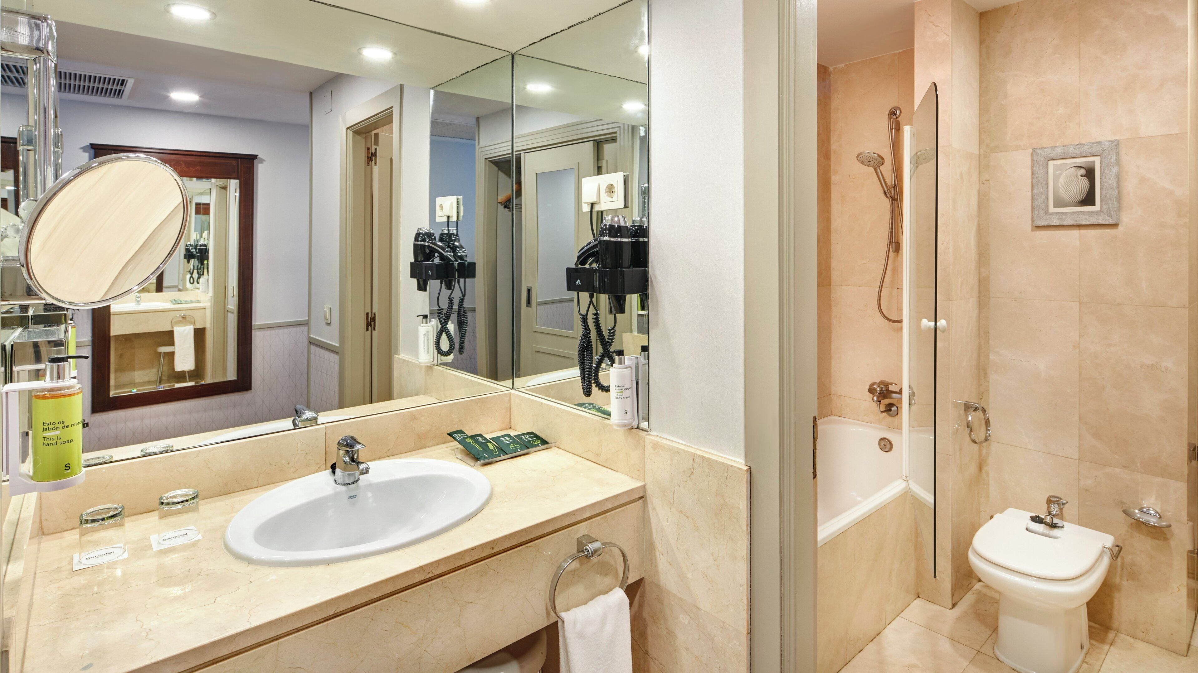 A bathroom with a sink, mirror, towel rack, and a shower area.