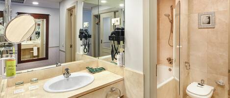 A bathroom with a sink, mirror, towel rack, and a shower area.