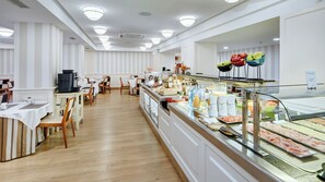 A buffet area with a variety of food options, a coffee station, and seating arrangements. - Sercotel Gran Hotel Conde Duque (Madrid)