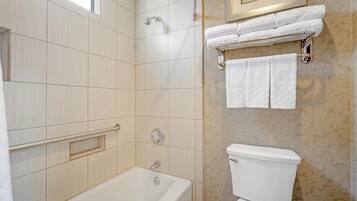 Une salle de bain avec une baignoire, des toilettes et un porte-serviettes.