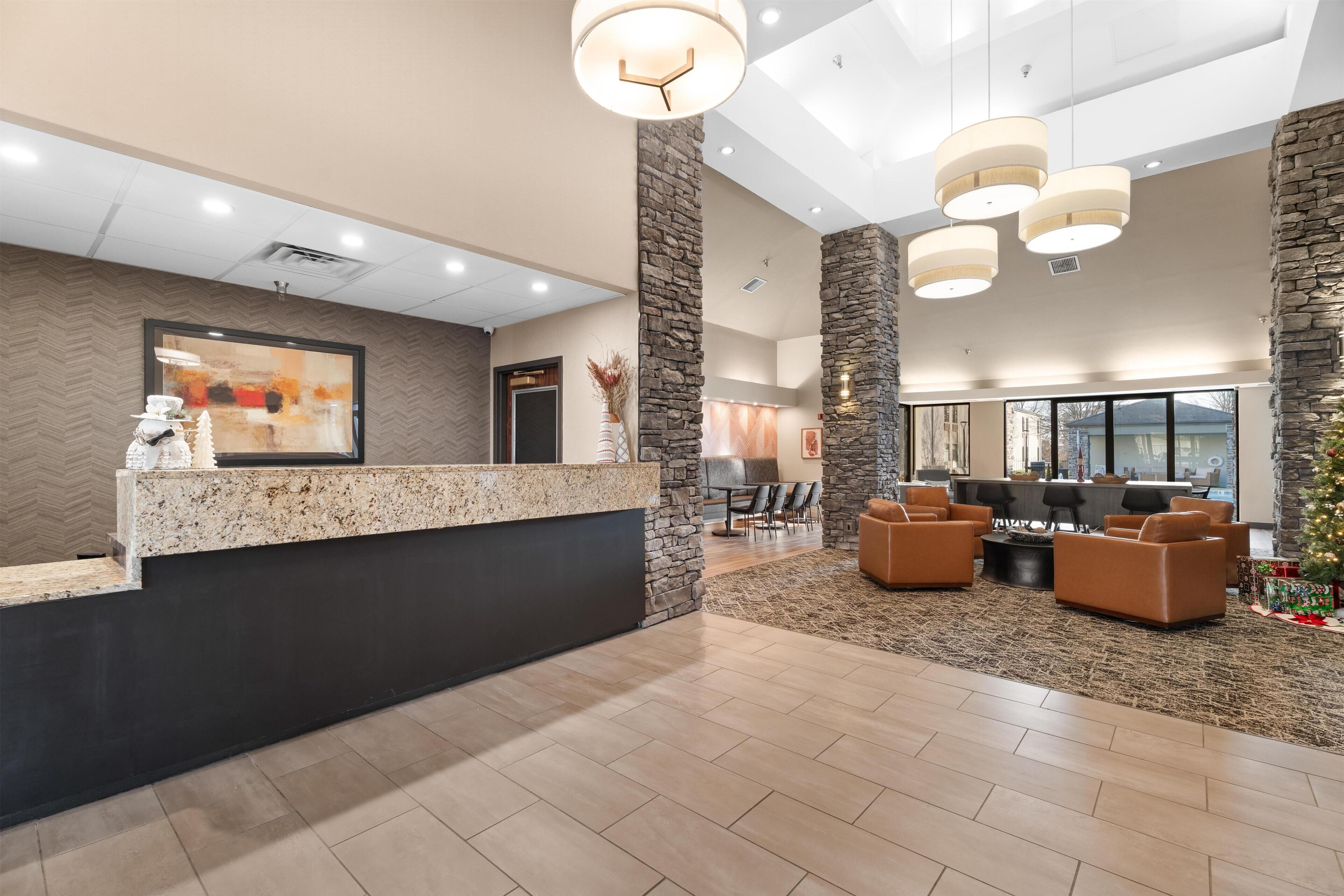 A reception area with a stone accent wall, a reception desk, and a seating area with sofas and a coffee table.