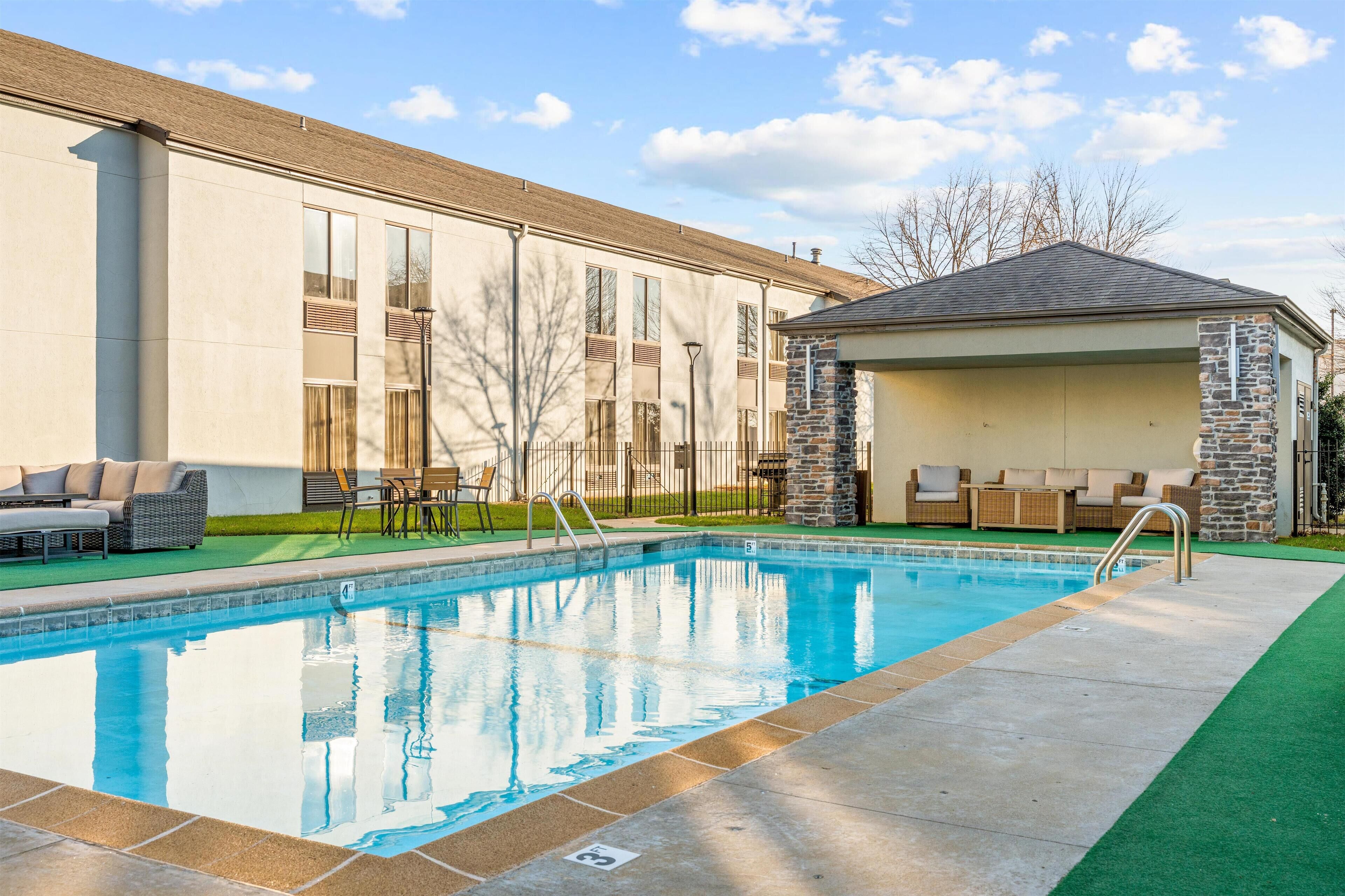 A swimming pool with a stone structure and outdoor seating area.