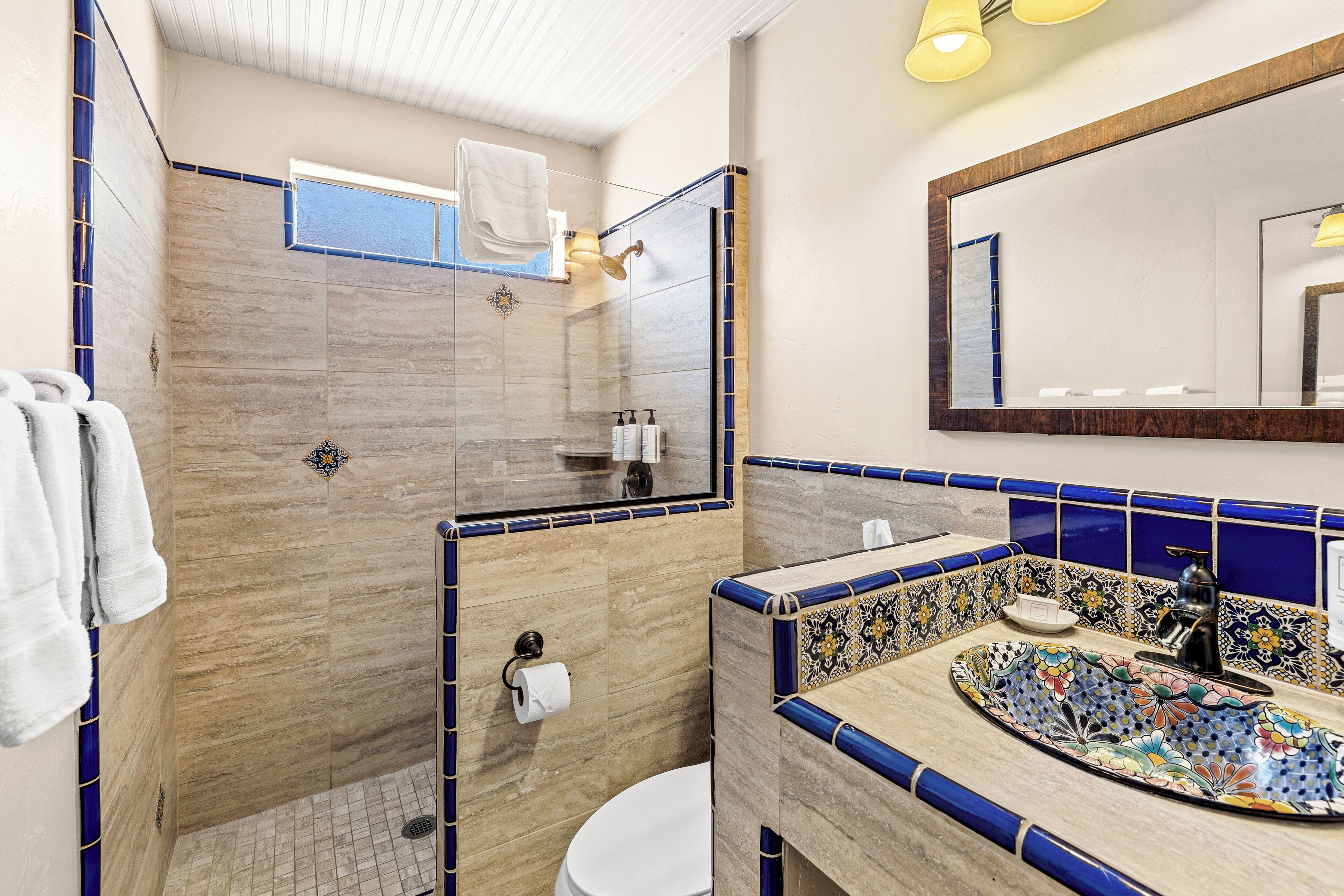 A bathroom with a shower, toilet, and sink.