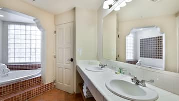 A bathroom with two sinks, a large mirror, and a window with a view.