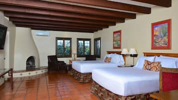 A hotel room with two beds, a fireplace, and a TV.