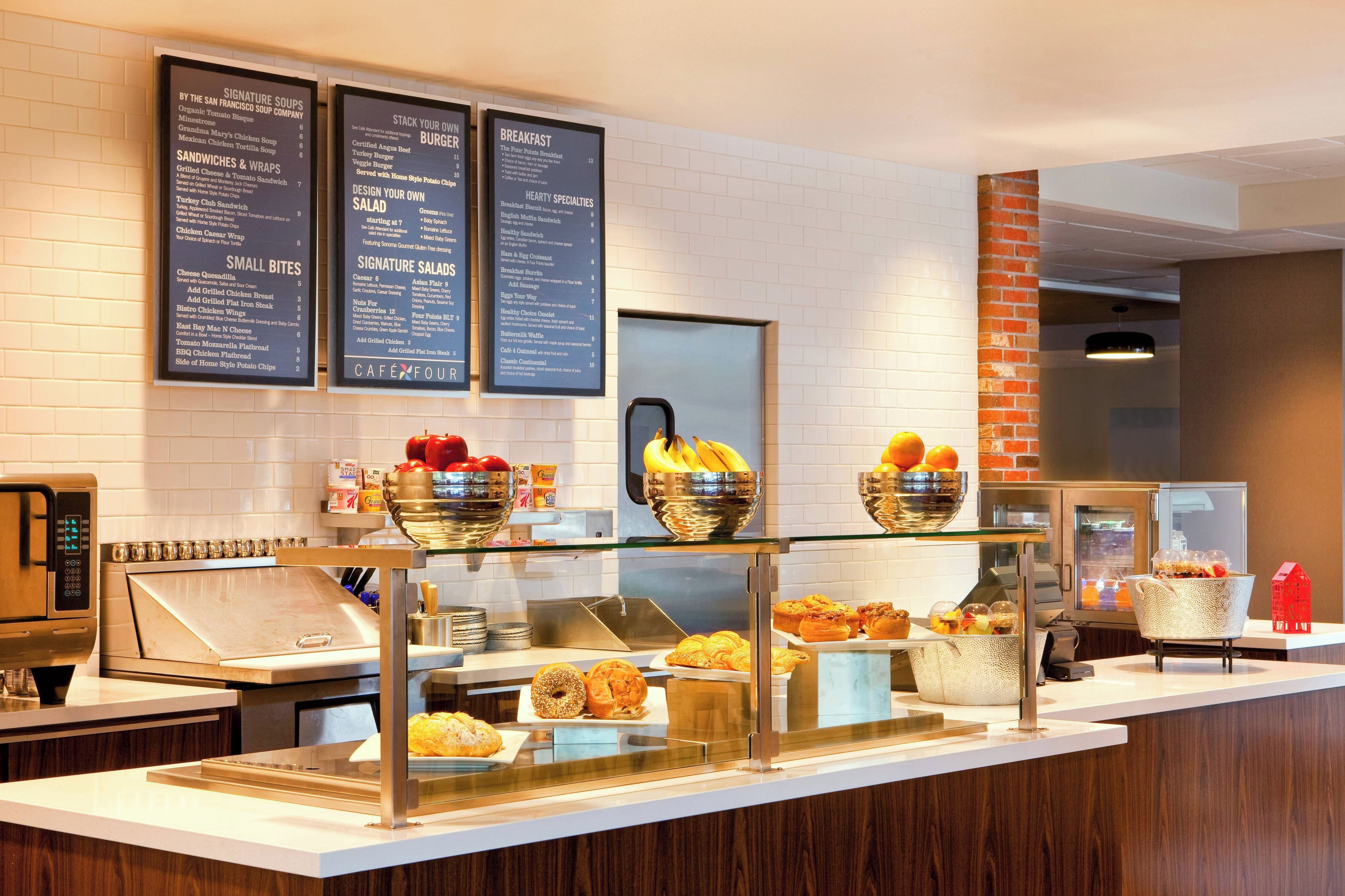 A breakfast buffet area with various food options and a menu board.