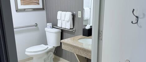 A modern bathroom with a toilet, sink, and towel rack.