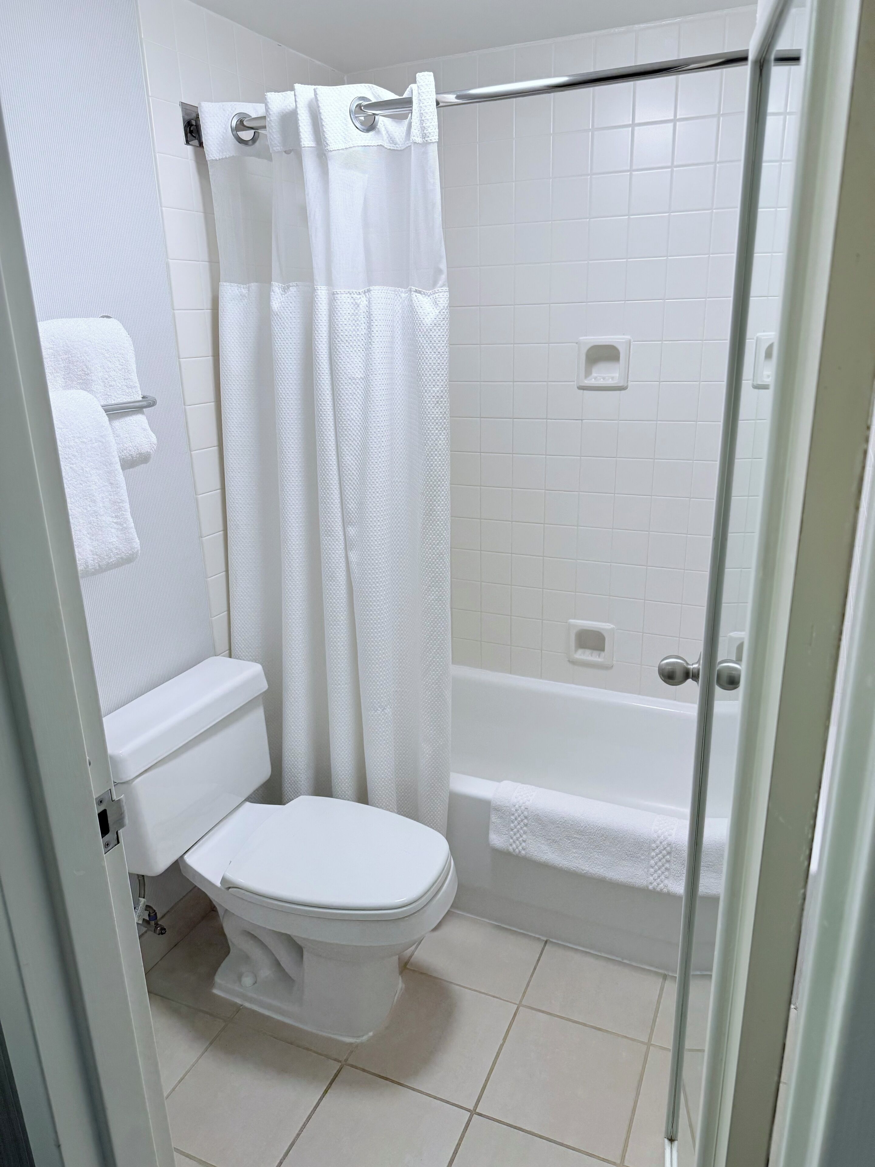 A bathroom with a toilet, a shower with a glass door, and a bathtub.