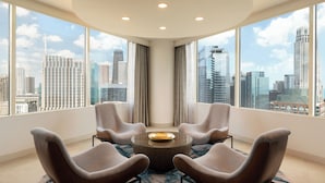 A modern hotel room with a large window offering a city skyline view, a round table with four chairs, and a ceiling with recessed lighting. - Swissotel - Chicago (Chicago)
