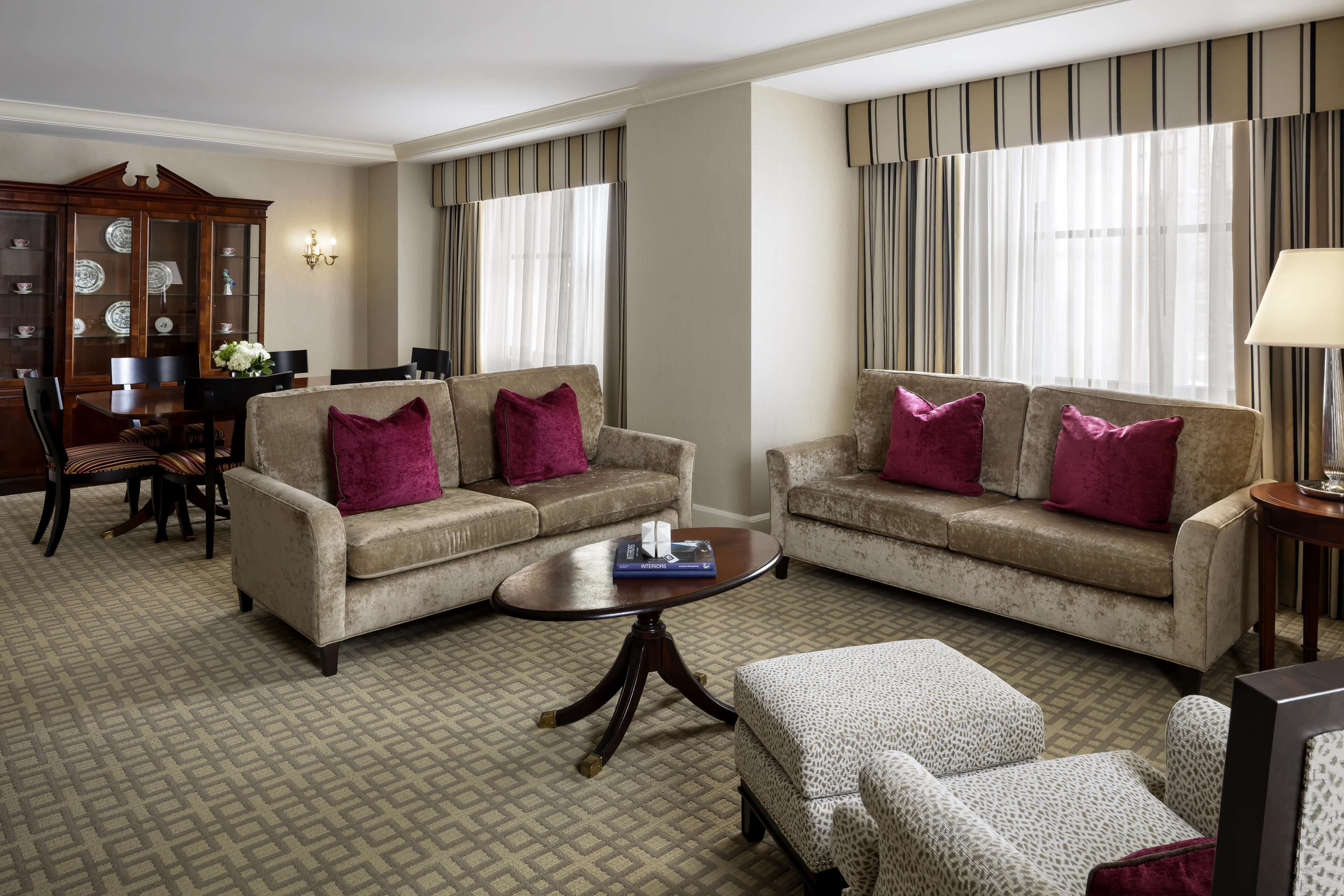 A living room with two sofas, a coffee table, and a patterned carpet.