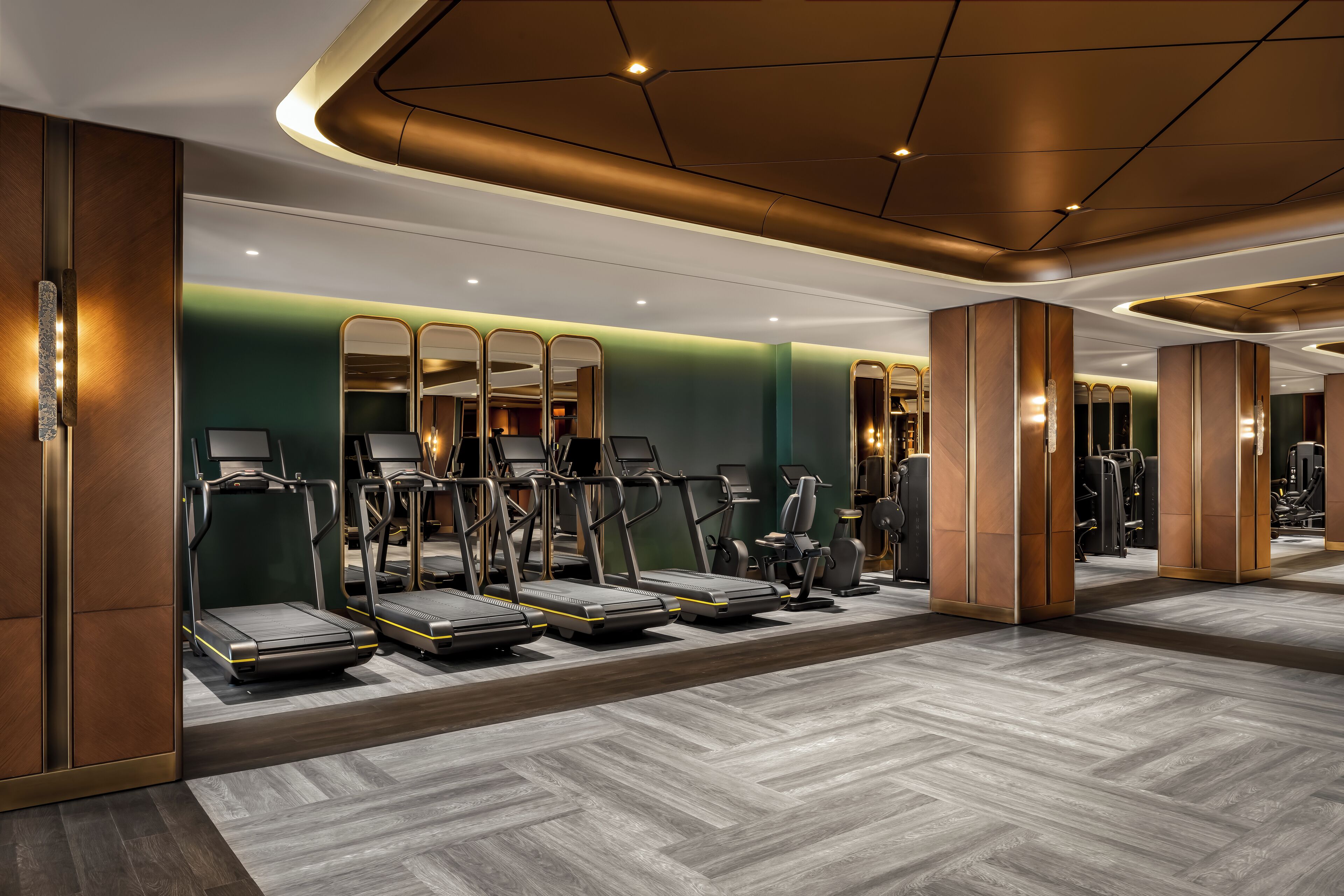 A modern gym with treadmills, exercise bikes, and weight machines.
