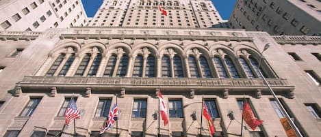 La façade de l’hôtel Royal York, ornée de nombreux drapeaux, dont le drapeau américain, et un ciel d’un bleu éclatant.