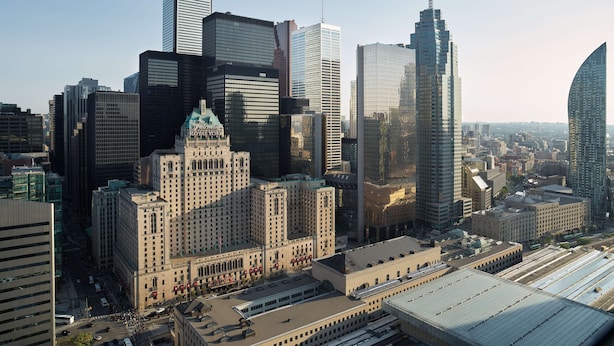 A cityscape with a mix of modern and historic buildings, including a prominent Art Deco structure.