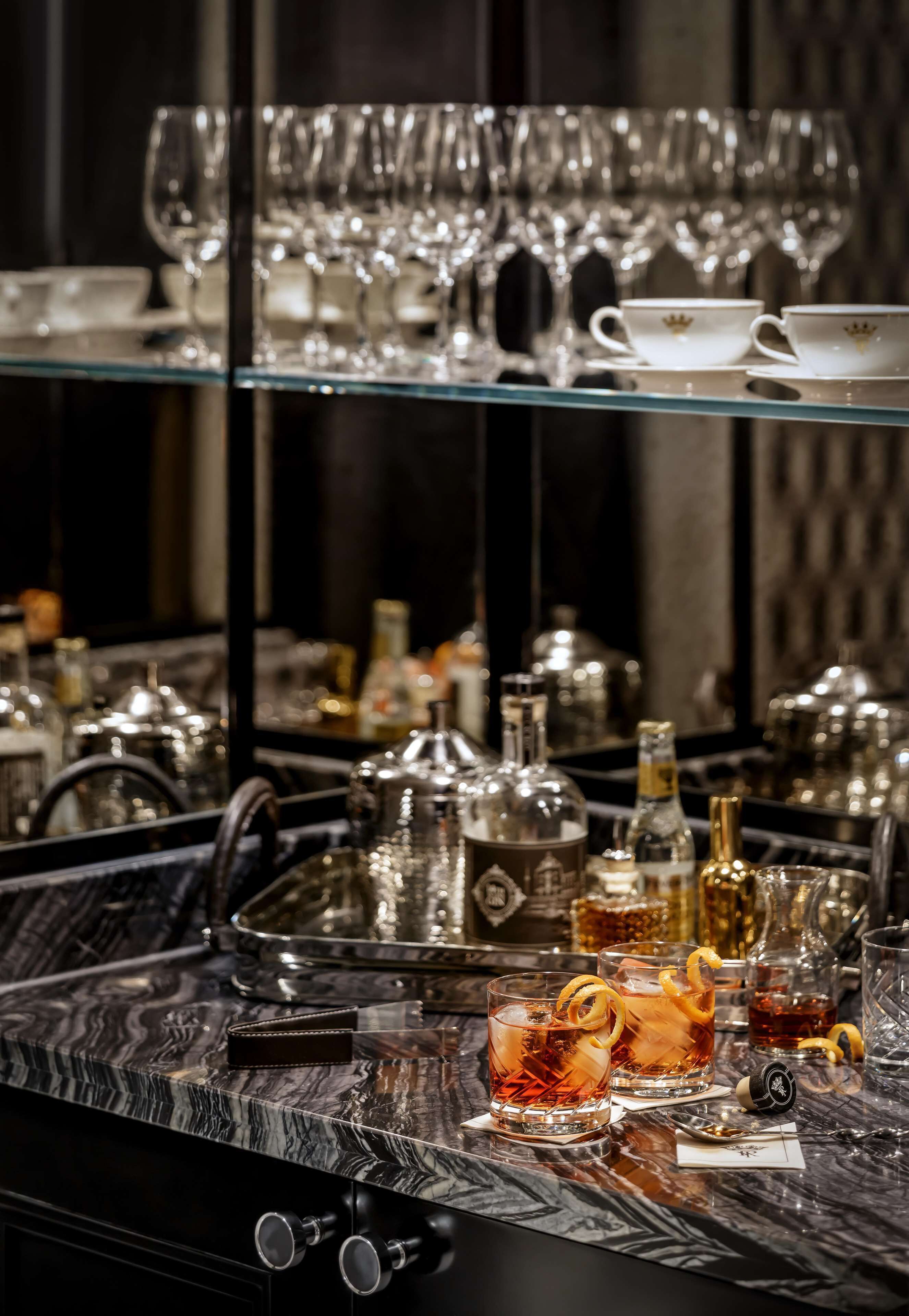 Un espace bar doté d’une variété de verres et de bouteilles, notamment des verres à boire, des bouteilles et des carafes.