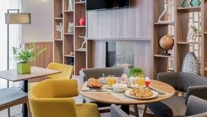 Una mesa con sillas y una variedad de comida y bebidas para el desayuno.