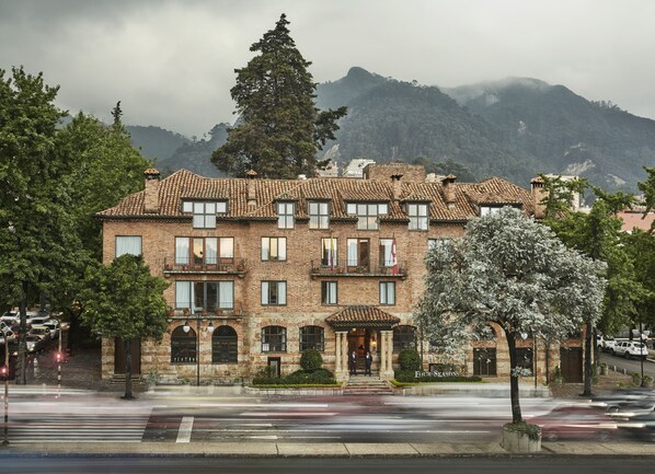 A multi-story building with a traditional brick facade, multiple balconies, and a sign reading "Four Seasons."