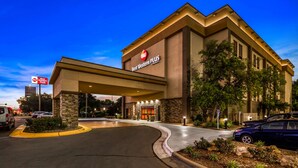 A Best Western Plus hotel with a modern facade, a covered entrance, and a landscaped driveway.