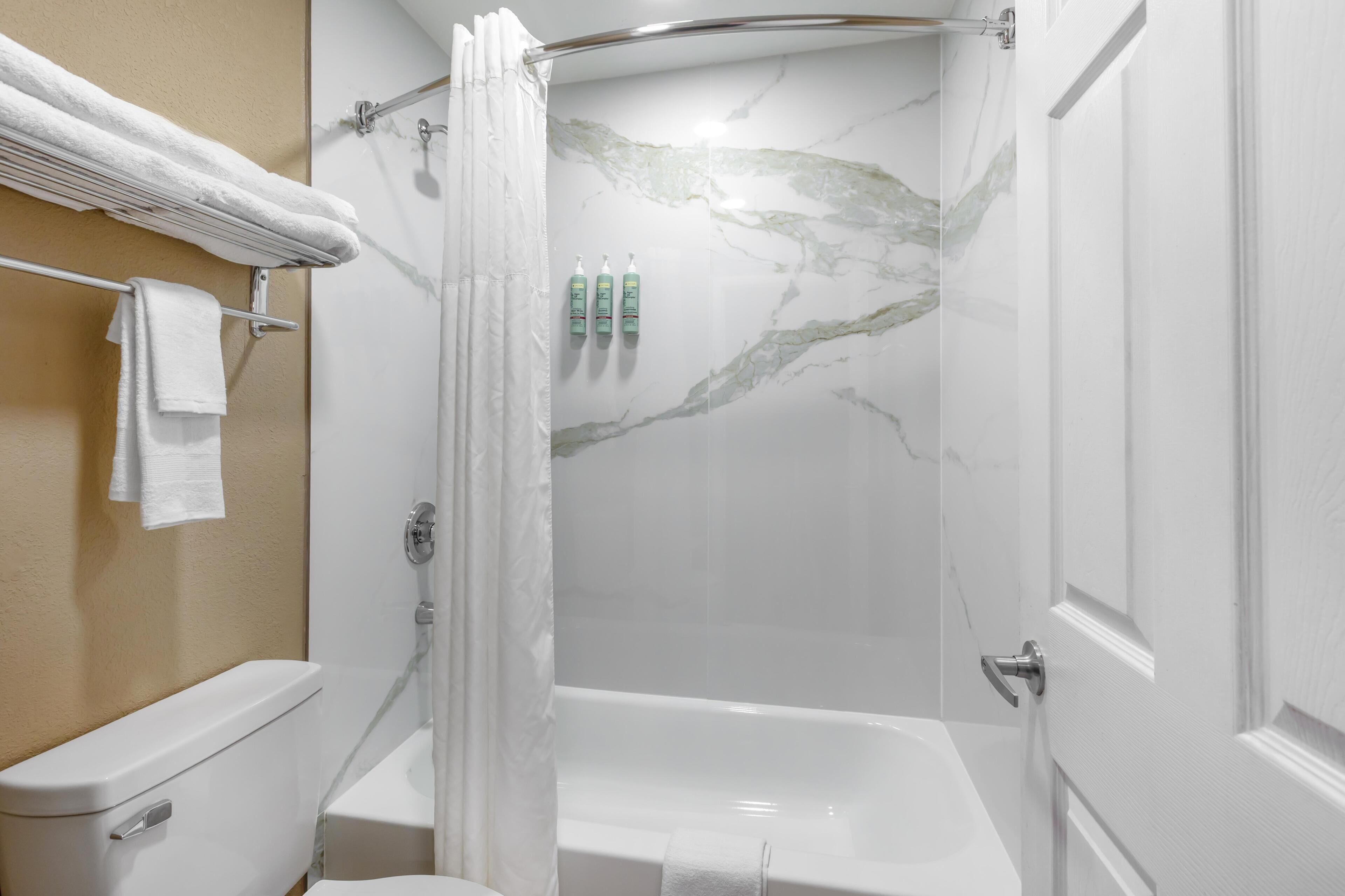 Un baño con ducha, inodoro y bañera.