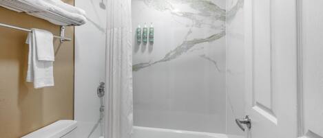 Un baño con ducha, inodoro y bañera.
