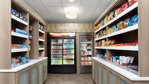 Un supermercado limpio y bien organizado, con gran variedad de productos en estantes y áreas refrigeradas.