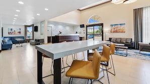 Amplia sala de estar con una mesa de comedor, sofás y una cocina al fondo.