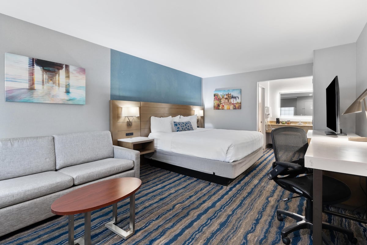 Een hotelkamer met een bed, een bank, een bureau en een televisie.