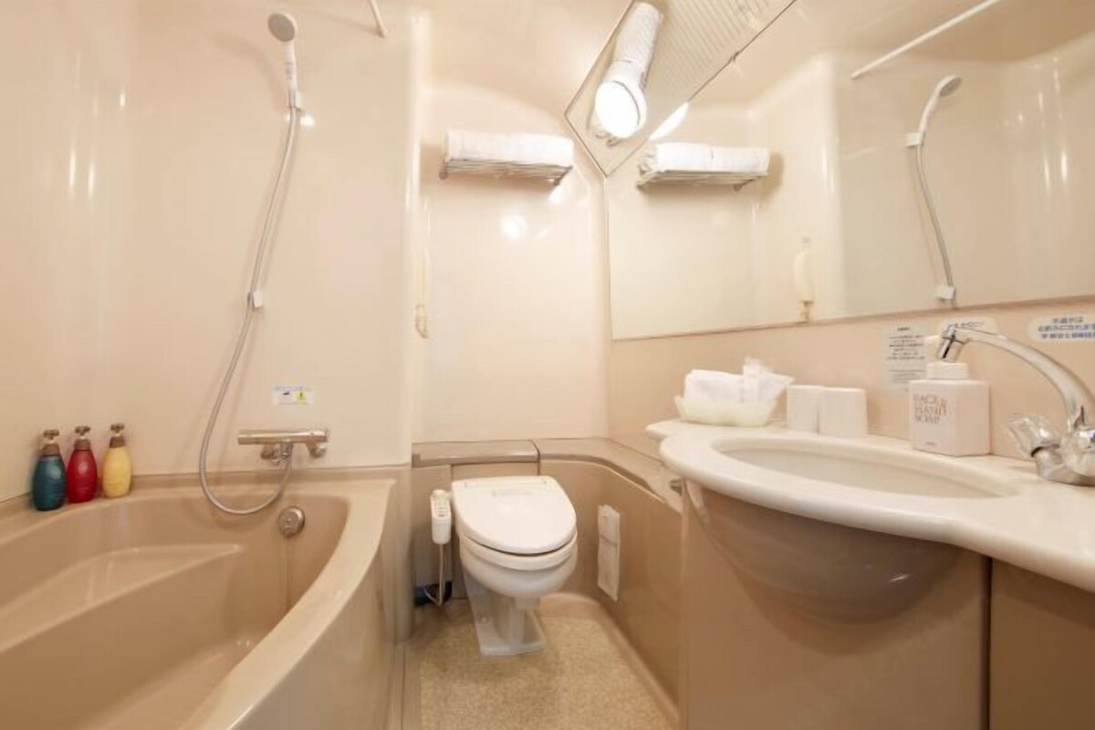 Een kleine badkamer met een bad, toilet en wastafel.
