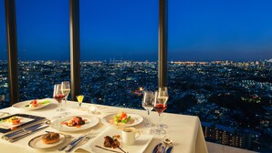Une table dressée pour le dîner, avec vue sur le paysage urbain.