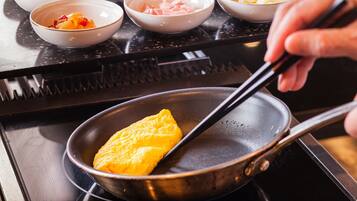 A person cooking an omelette in a pan on a stove.