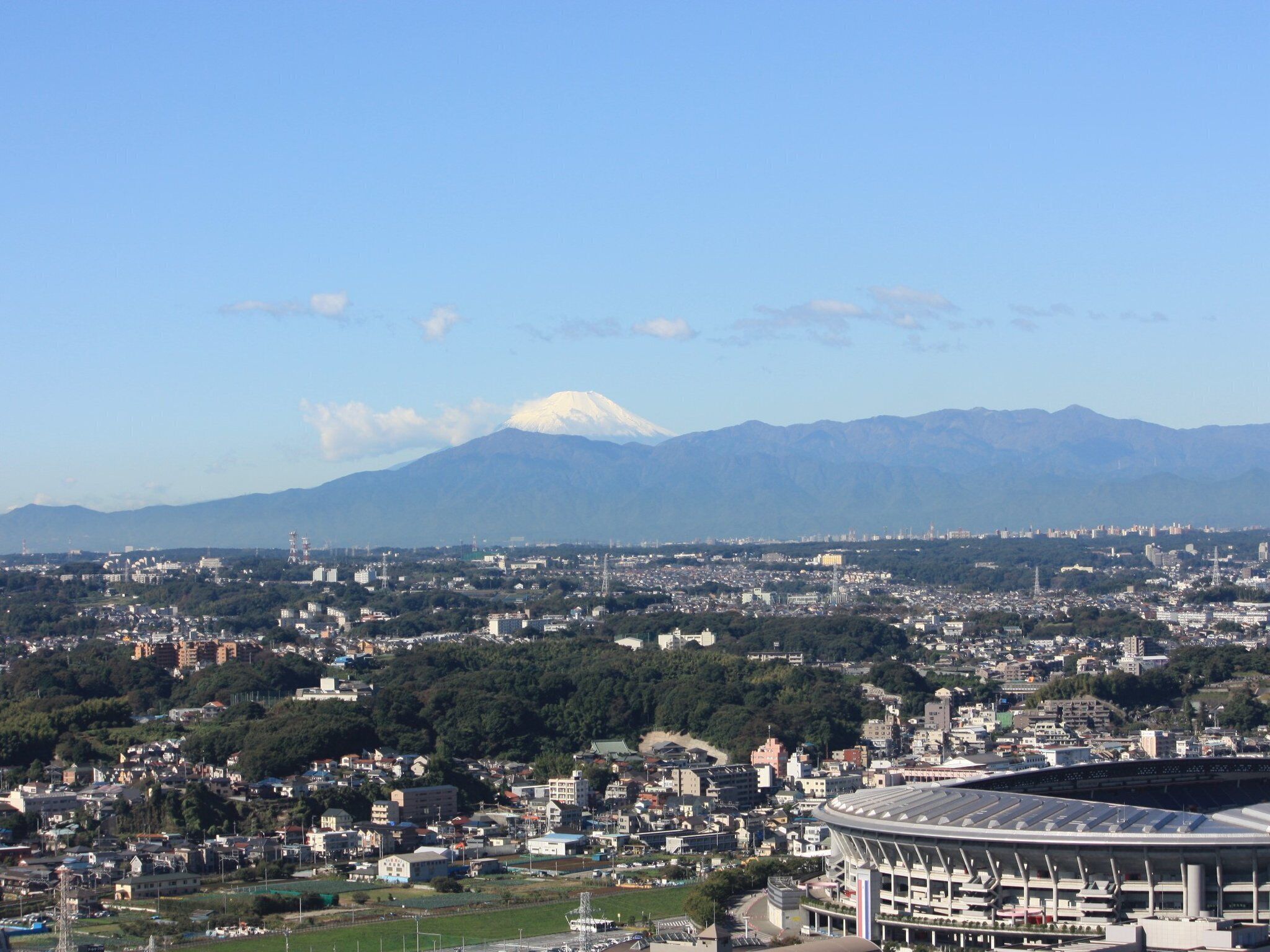 A stadium with a view of a cityscape and a mountain in the background.