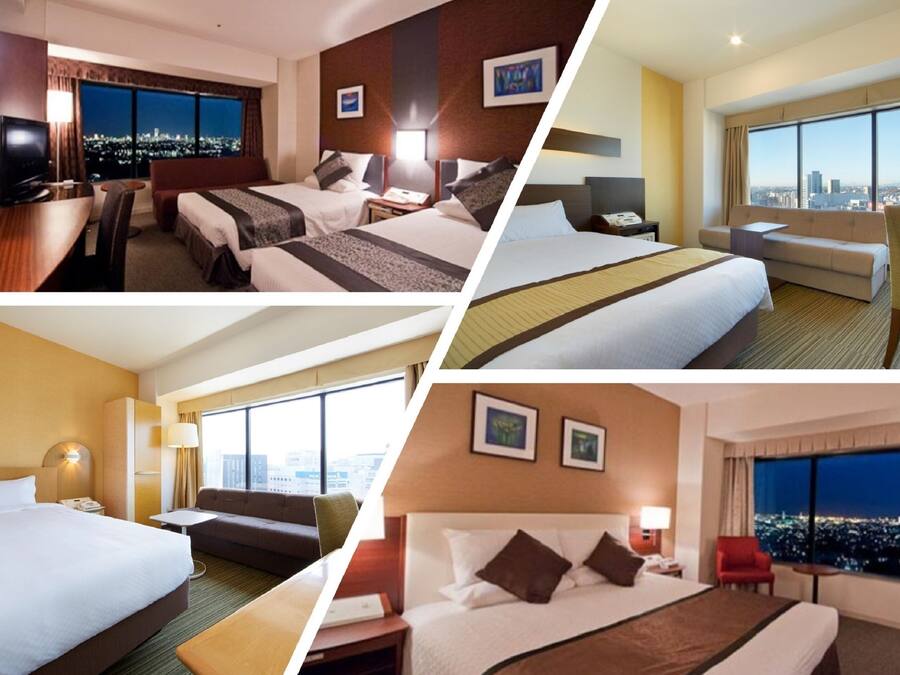 Habitación de hotel con vistas a la ciudad, una cama, un escritorio y un sofá.