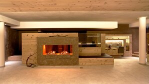 Un interior moderno con chimenea central, zona de cocina y espacio para sentarse.