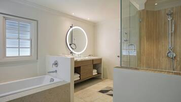 Een moderne badkamer met een badkuip, een wastafel met spiegel en een douche.
