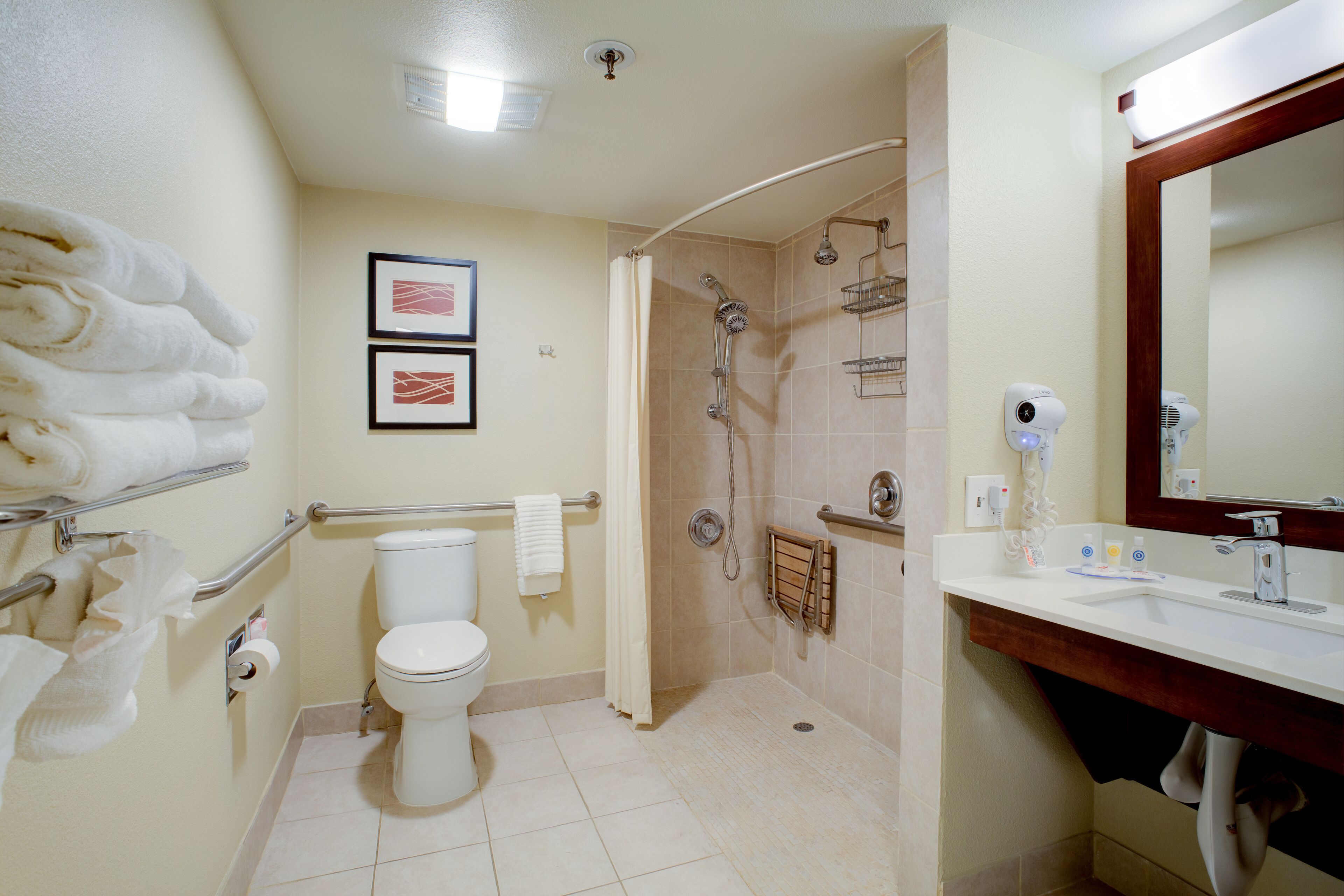 A bathroom with a toilet, shower, and sink.