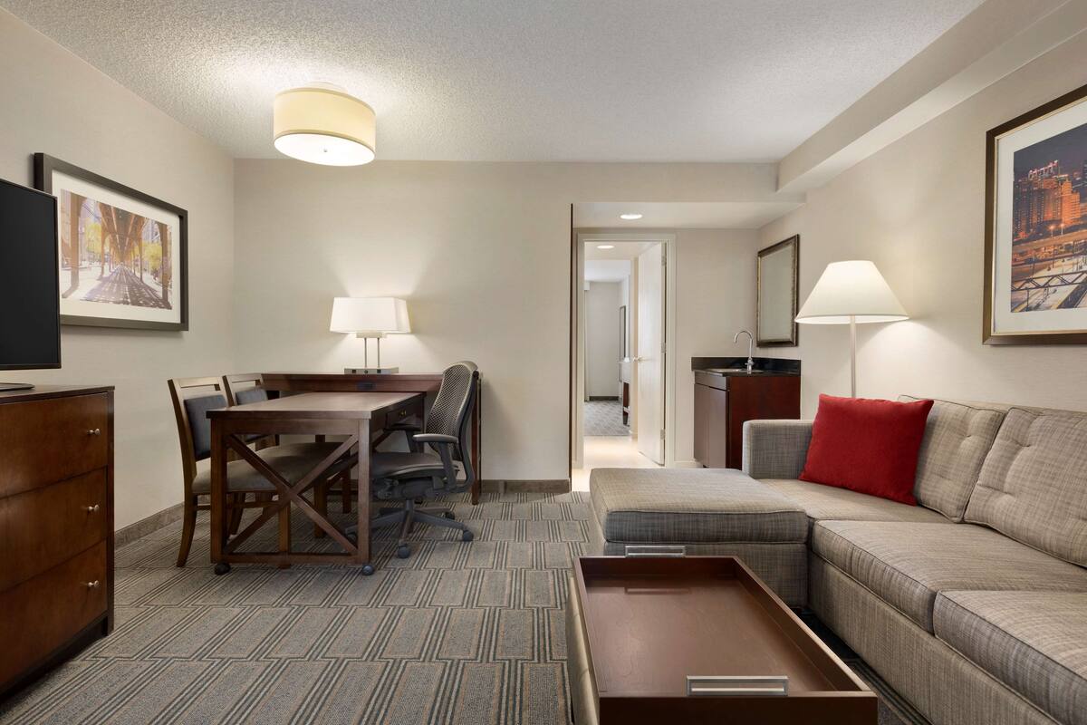 Une chambre d’hôtel équipée d’une table à manger, d’un canapé, d’une télévision et d’un lit.