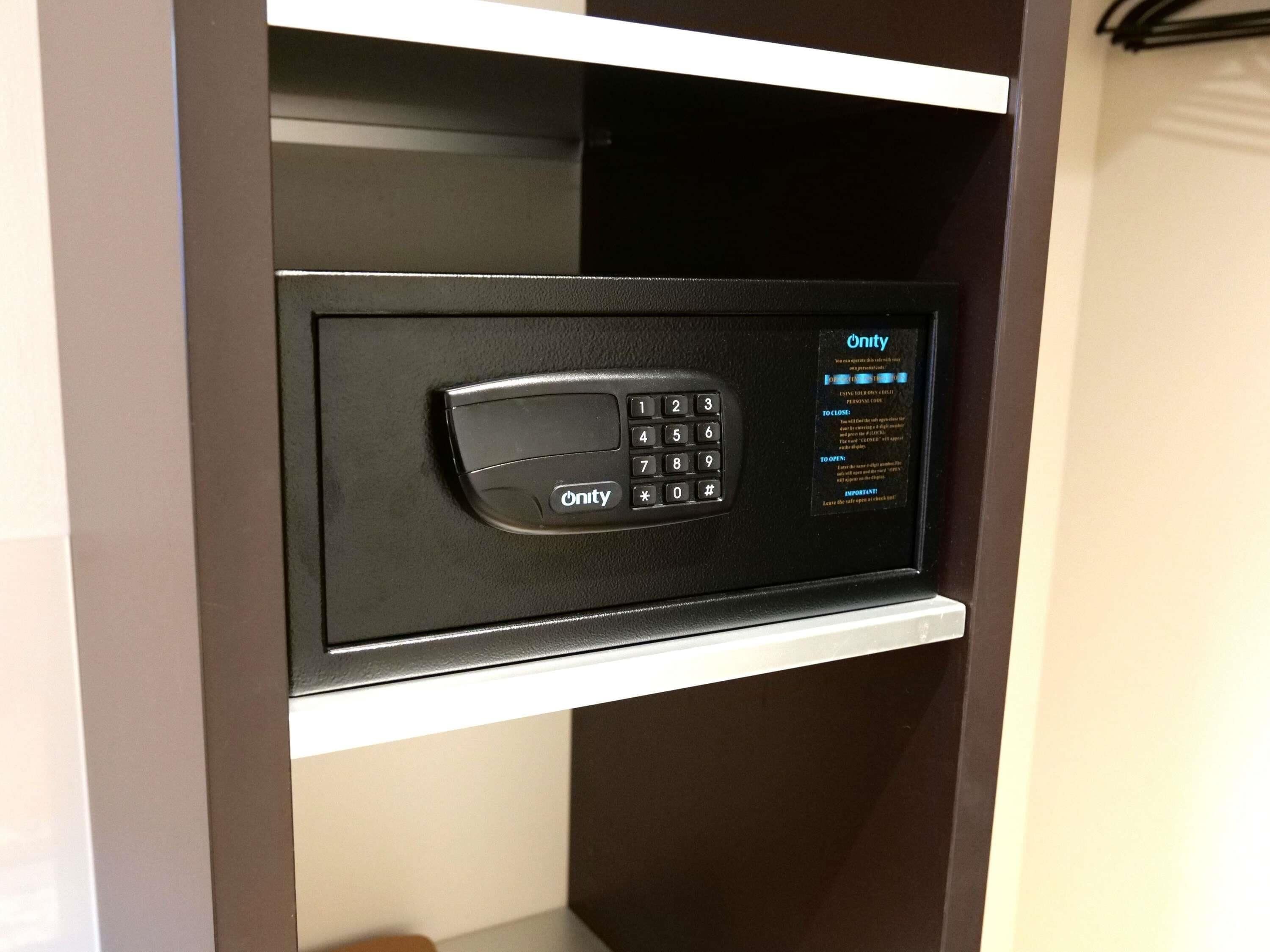 A black electronic keypad lock on a white shelf.