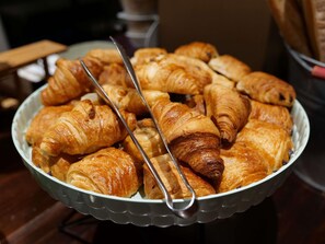 A bowl of assorted pastries, including croissants and other baked goods.