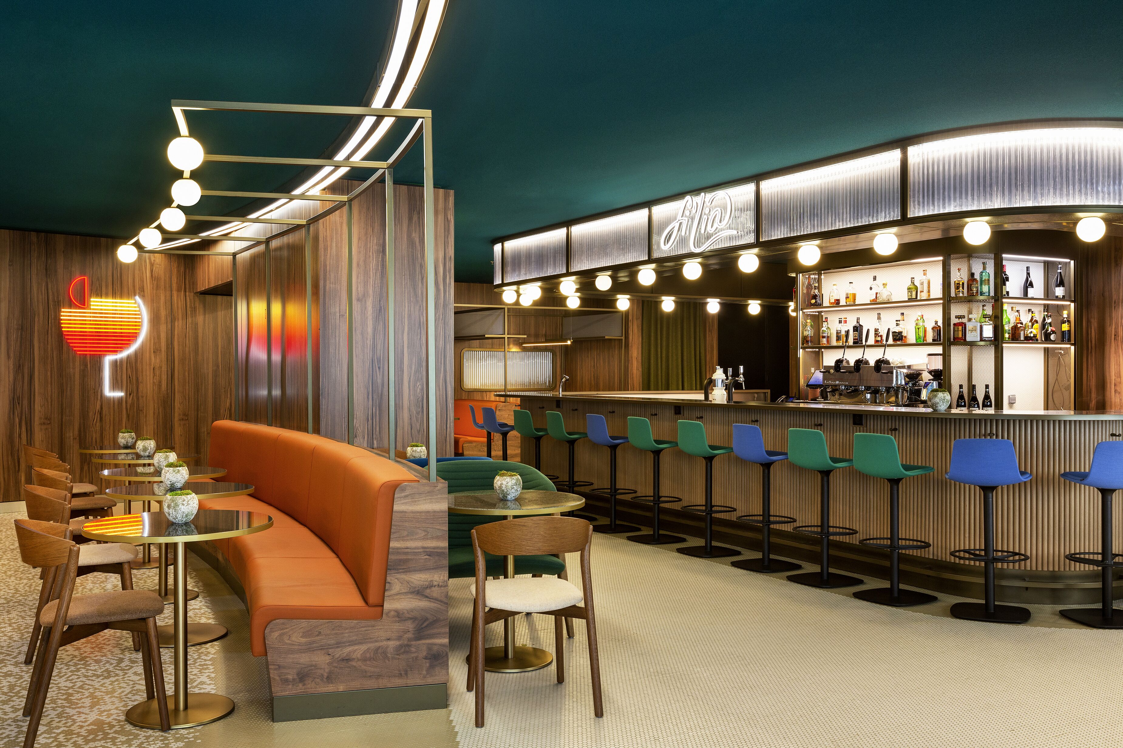 A bar area with a curved counter, multiple stools, and a seating area with a sofa and chairs.