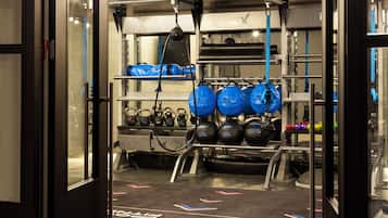 A gym with kettlebells, dumbbells, and exercise balls.