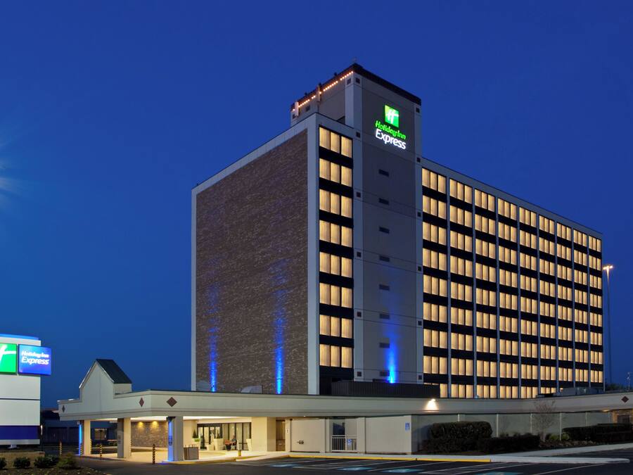 A Holiday Inn Express hotel with a modern design, featuring a prominent sign and a well-lit entrance.