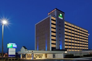 A Holiday Inn Express hotel with a modern design, featuring a prominent sign and a well-lit entrance.