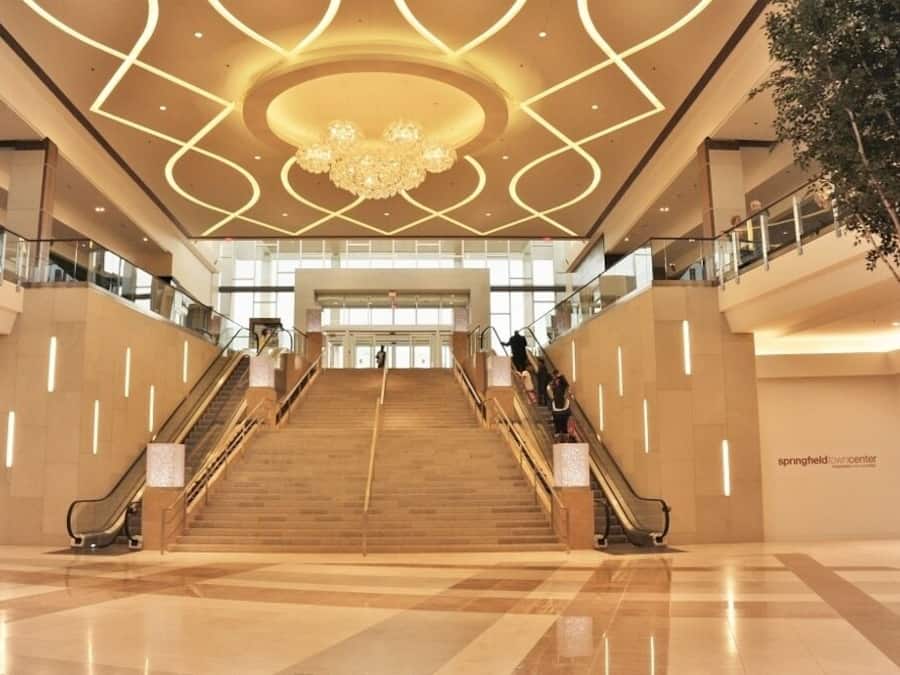 A spacious interior with a grand staircase, a chandelier, and a modern design.