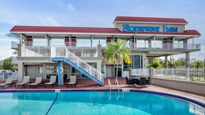 A hotel with a pool, a red roof, and a sign that reads "Rodeway Inn". - Rodeway Inn Clearwater - Largo (Clearwater)