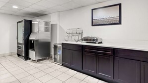 A modern kitchen with stainless steel appliances, a white countertop, and a framed picture on the wall. - Red Lion Inn & Suites Pontoon Beach (Granite City)